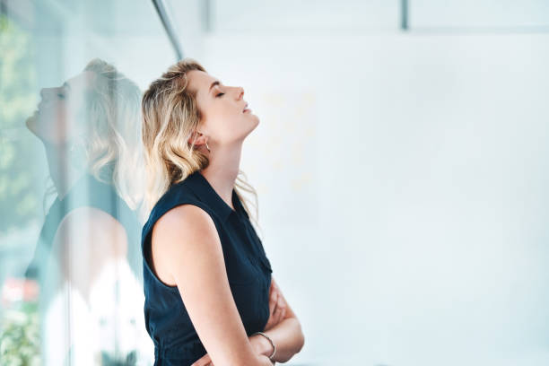 Shot of a young businesswoman looking stressed out in an office two people sitting during day